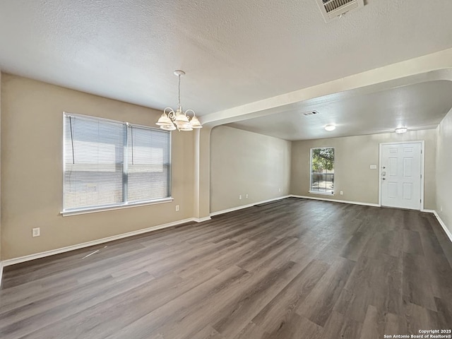 1754 Barking Wolf, San Antonio, TX 78245 - unfurnished room featuring an inviting chandelier, dark wood-type flooring, visible vents, and a textured ceiling