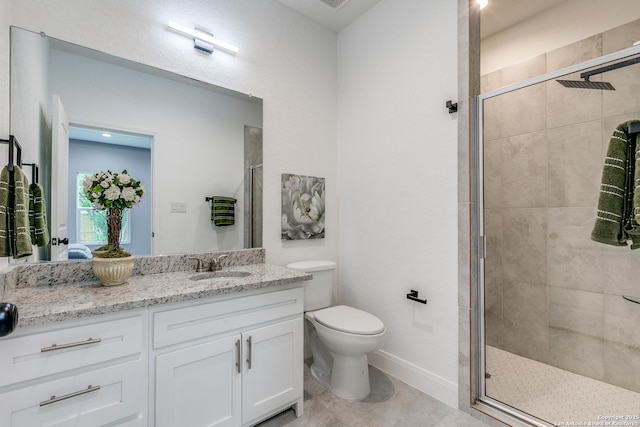 bathroom featuring toilet, a shower stall, vanity, and baseboards
