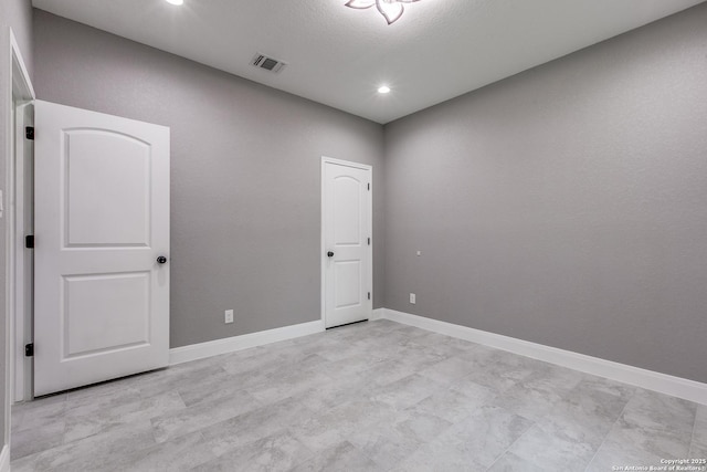 empty room featuring recessed lighting, visible vents, and baseboards