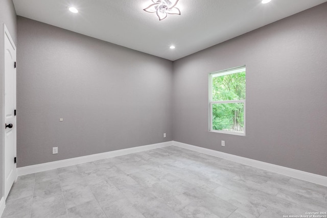 unfurnished room featuring recessed lighting and baseboards
