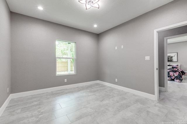 unfurnished room featuring recessed lighting and baseboards