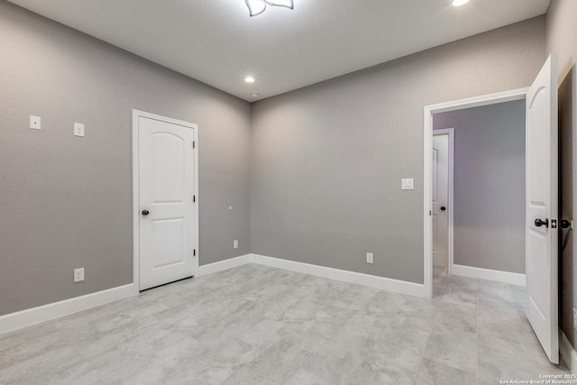 empty room featuring recessed lighting and baseboards