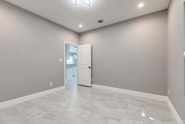 unfurnished room featuring baseboards, visible vents, and recessed lighting