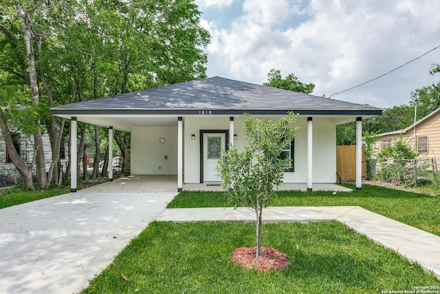 view of front of property with an attached carport, a front lawn, stucco siding, and fence
