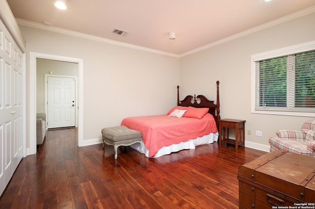 bedroom featuring baseboards, ornamental molding, wood finished floors, and visible vents