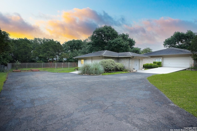 view of front of house with a garage, a front lawn, fence, and driveway