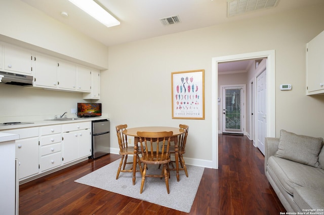 interior space with visible vents, fridge, dark wood-style floors, under cabinet range hood, and a sink