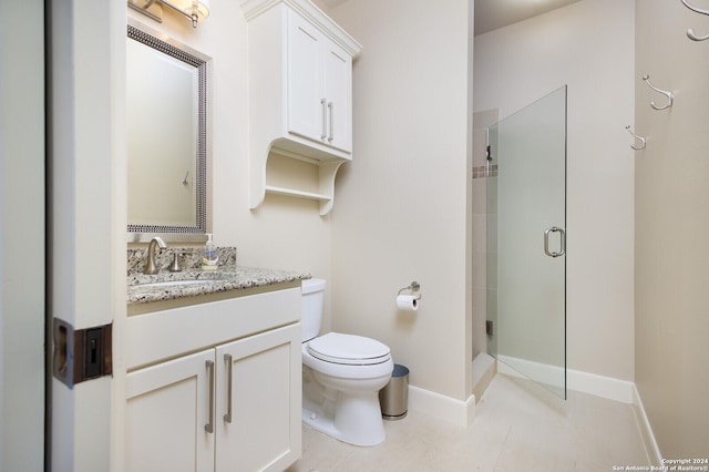 bathroom with vanity, baseboards, toilet, and a shower stall
