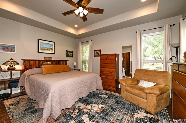 bedroom with recessed lighting, ceiling fan, wood finished floors, and a raised ceiling