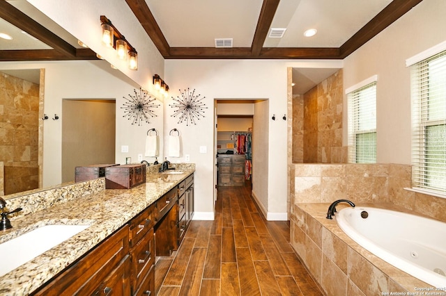 bathroom with a sink, a whirlpool tub, and visible vents