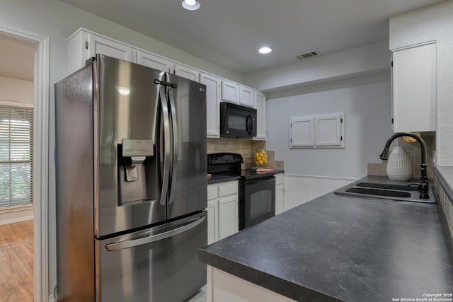 2215 Shady Rock Cir, San Antonio, TX 78231 - kitchen featuring black appliances, a sink, dark countertops, white cabinetry, and recessed lighting