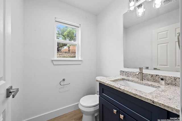 1050 Trail Pass Dr, Canyon Lake, TX 78133 - half bathroom with visible vents, wood finished floors, baseboards, vanity, and toilet