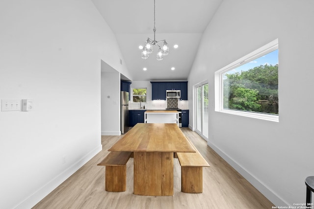 1050 Trail Pass Dr, Canyon Lake, TX 78133 - unfurnished dining area featuring an inviting chandelier, high vaulted ceiling, baseboards, and light wood-style floors
