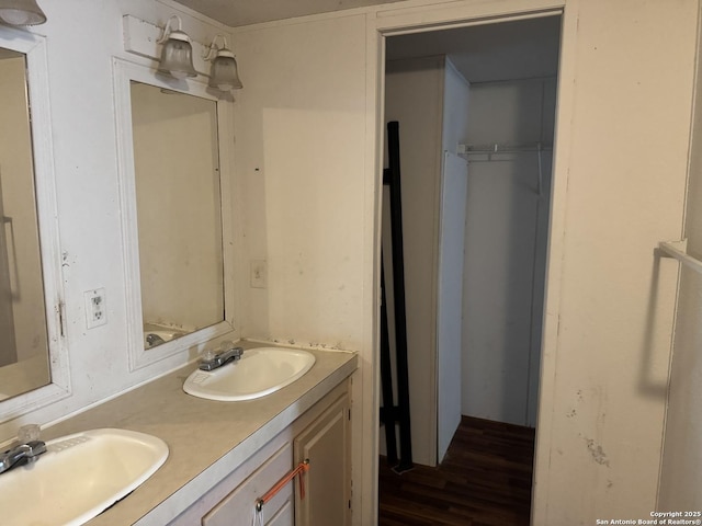full bath featuring double vanity, a sink, and wood finished floors