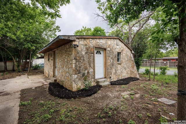 view of outbuilding with fence and an outdoor structure