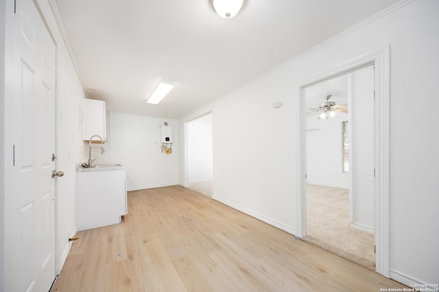 laundry room featuring baseboards, ornamental molding, and light wood-style flooring