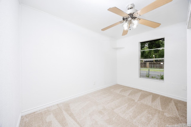 carpeted empty room featuring a ceiling fan and baseboards