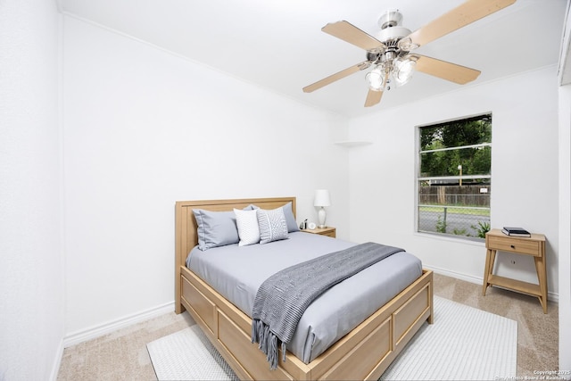 bedroom featuring baseboards, ceiling fan, and light carpet