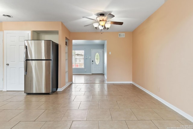 interior space with freestanding refrigerator, a ceiling fan, baseboards, and visible vents