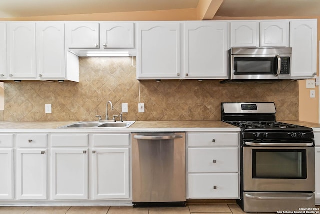 kitchen with white cabinets, stainless steel appliances, a sink, and light countertops