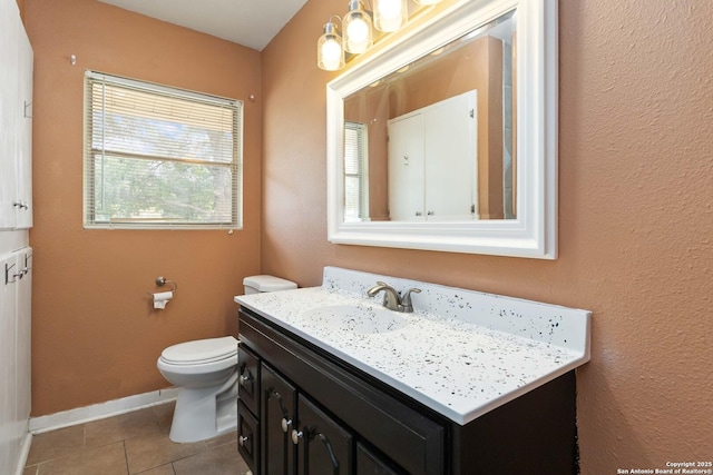 bathroom featuring toilet, tile patterned floors, baseboards, and vanity