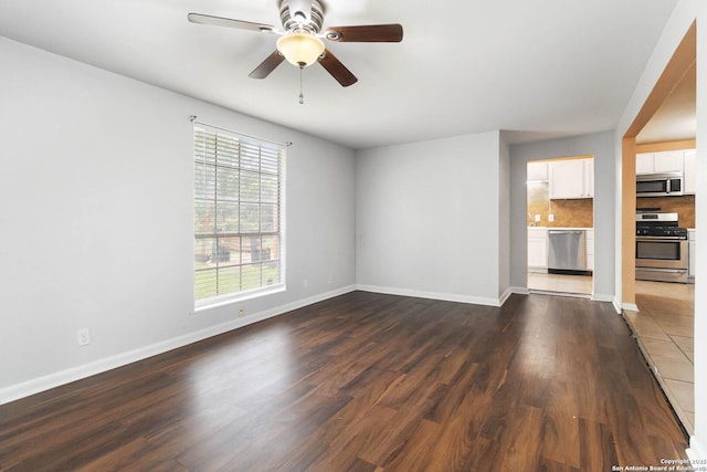 unfurnished living room with baseboards, dark wood finished floors, and ceiling fan