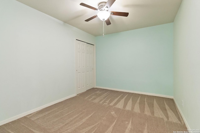 carpeted empty room featuring baseboards and a ceiling fan