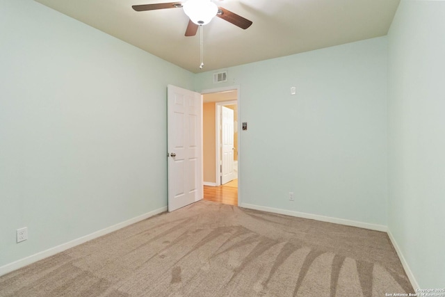unfurnished room with visible vents, baseboards, carpet floors, and ceiling fan