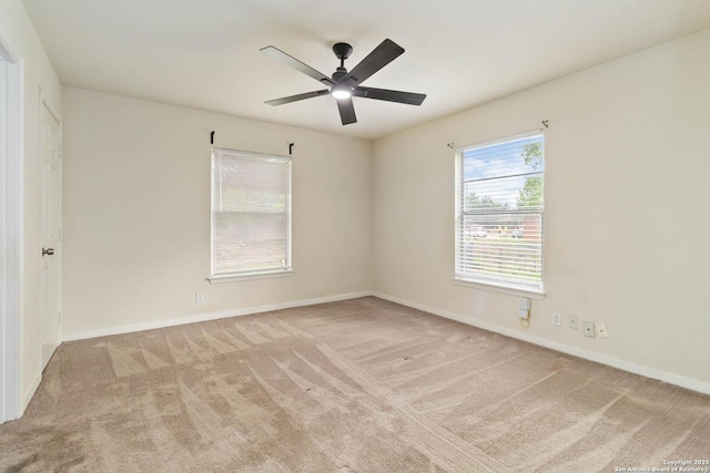carpeted empty room featuring baseboards and a ceiling fan
