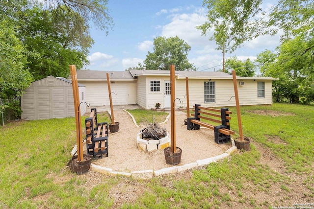 189 National, Universal City, TX 78148 - rear view of property featuring a lawn, a fire pit, a shed, and an outbuilding