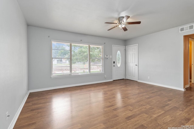 interior space featuring visible vents, a ceiling fan, baseboards, and dark wood-type flooring