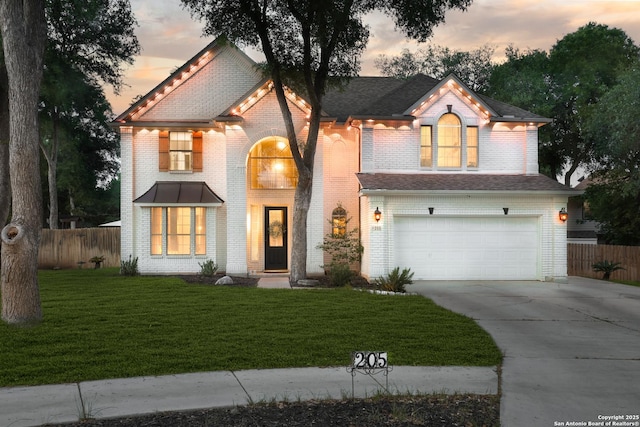 view of front of home with an attached garage, fence, a front yard, and concrete driveway