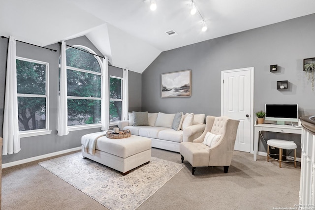living area with baseboards, visible vents, track lighting, and carpet