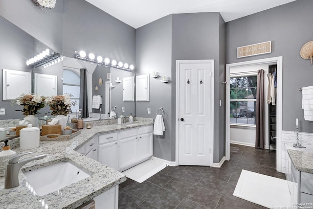 full bathroom with visible vents, double vanity, baseboards, tile patterned floors, and a sink