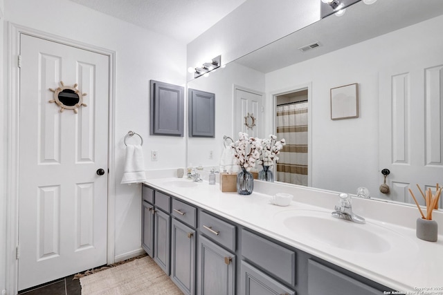 bathroom with double vanity, a sink, tile patterned flooring, and visible vents
