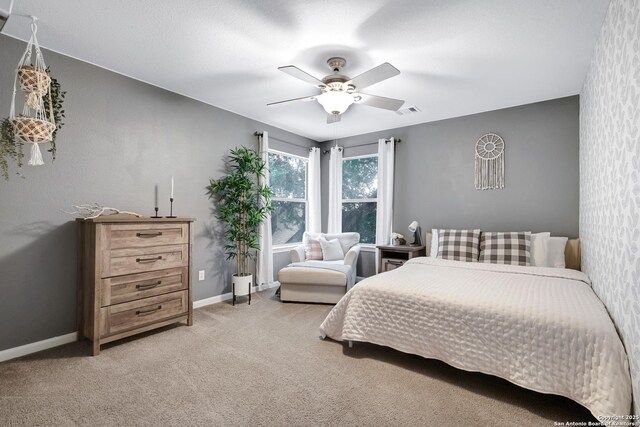 bedroom with visible vents, a ceiling fan, baseboards, and light carpet