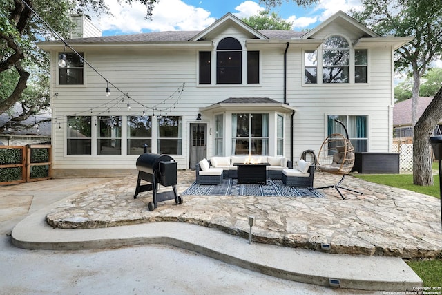 rear view of property featuring outdoor lounge area, a patio area, a chimney, and fence