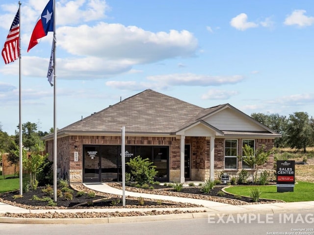 view of front of property featuring brick siding and a shingled roof