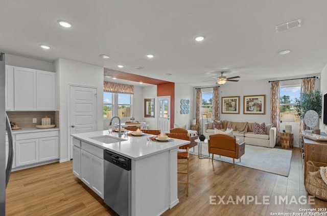 kitchen with visible vents, dishwasher, a sink, light countertops, and white cabinets