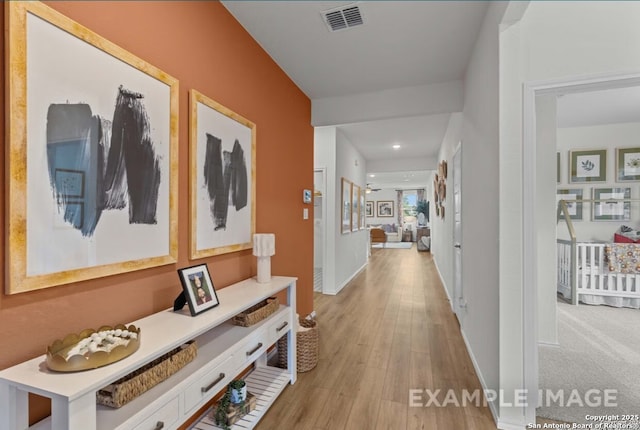 hallway with visible vents, recessed lighting, light wood-style flooring, and baseboards