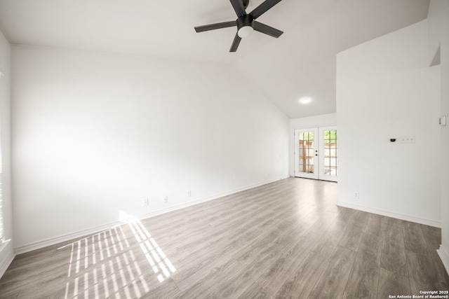 unfurnished living room featuring ceiling fan, french doors, wood finished floors, baseboards, and lofted ceiling