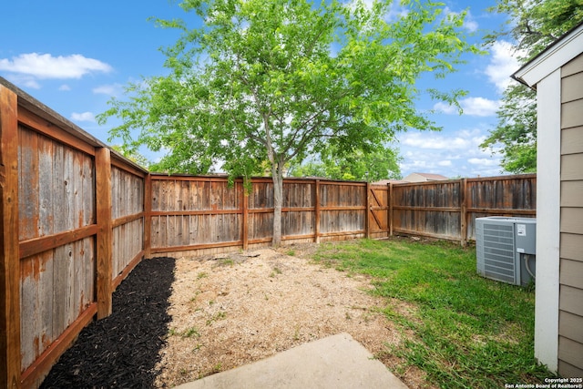 view of yard with a fenced backyard and central AC