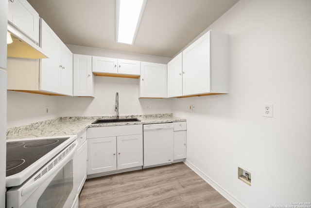 kitchen with a sink, white appliances, and white cabinetry