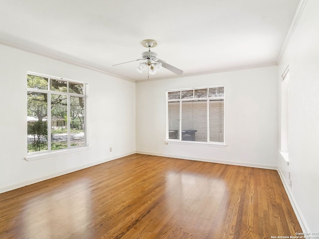 unfurnished room featuring crown molding, baseboards, and wood finished floors