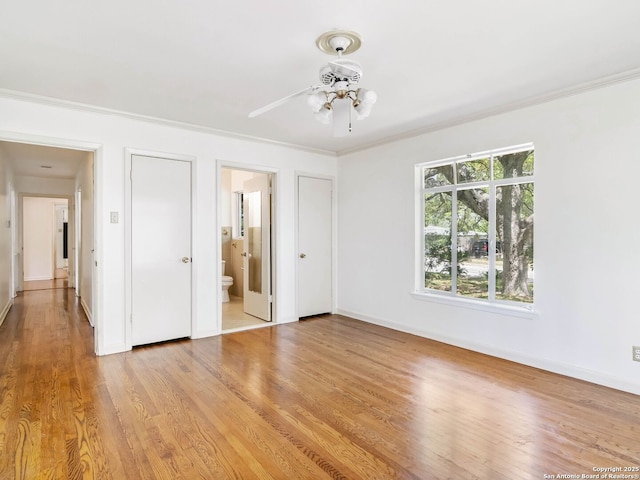 unfurnished bedroom with crown molding, baseboards, ensuite bathroom, and light wood finished floors