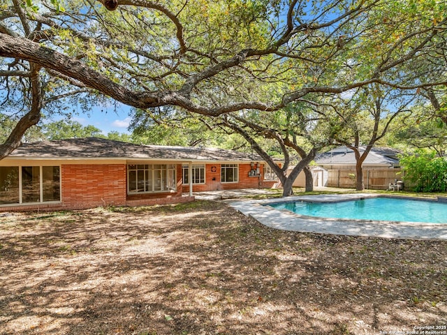 view of pool featuring fence, a shed, and a fenced in pool