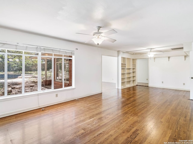 unfurnished room featuring baseboards, a ceiling fan, and wood finished floors
