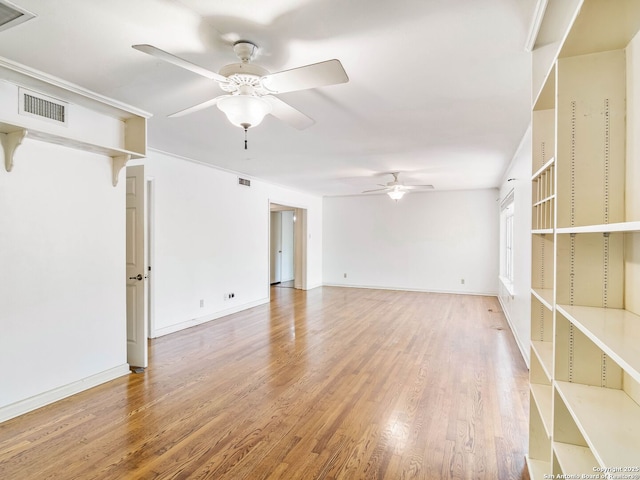 unfurnished room with ceiling fan, visible vents, and wood finished floors