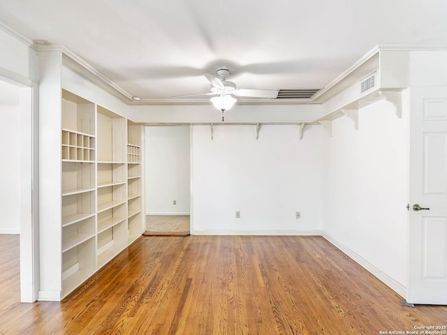 empty room featuring a ceiling fan, baseboards, visible vents, and wood finished floors