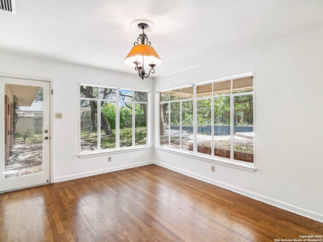 interior space featuring visible vents, baseboards, and wood finished floors